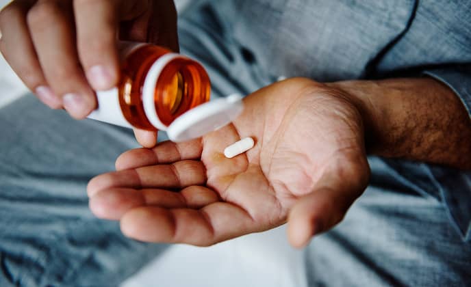 Pill being shaken out of a pill bottle